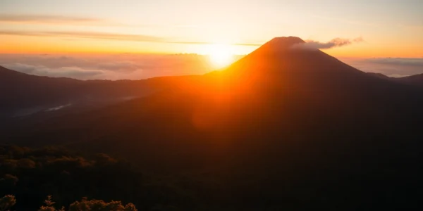 Hikers admiring the stunning view of Mt. Rinjani's active volcano peak on a clear day, emphasizing adventure and natural beauty.